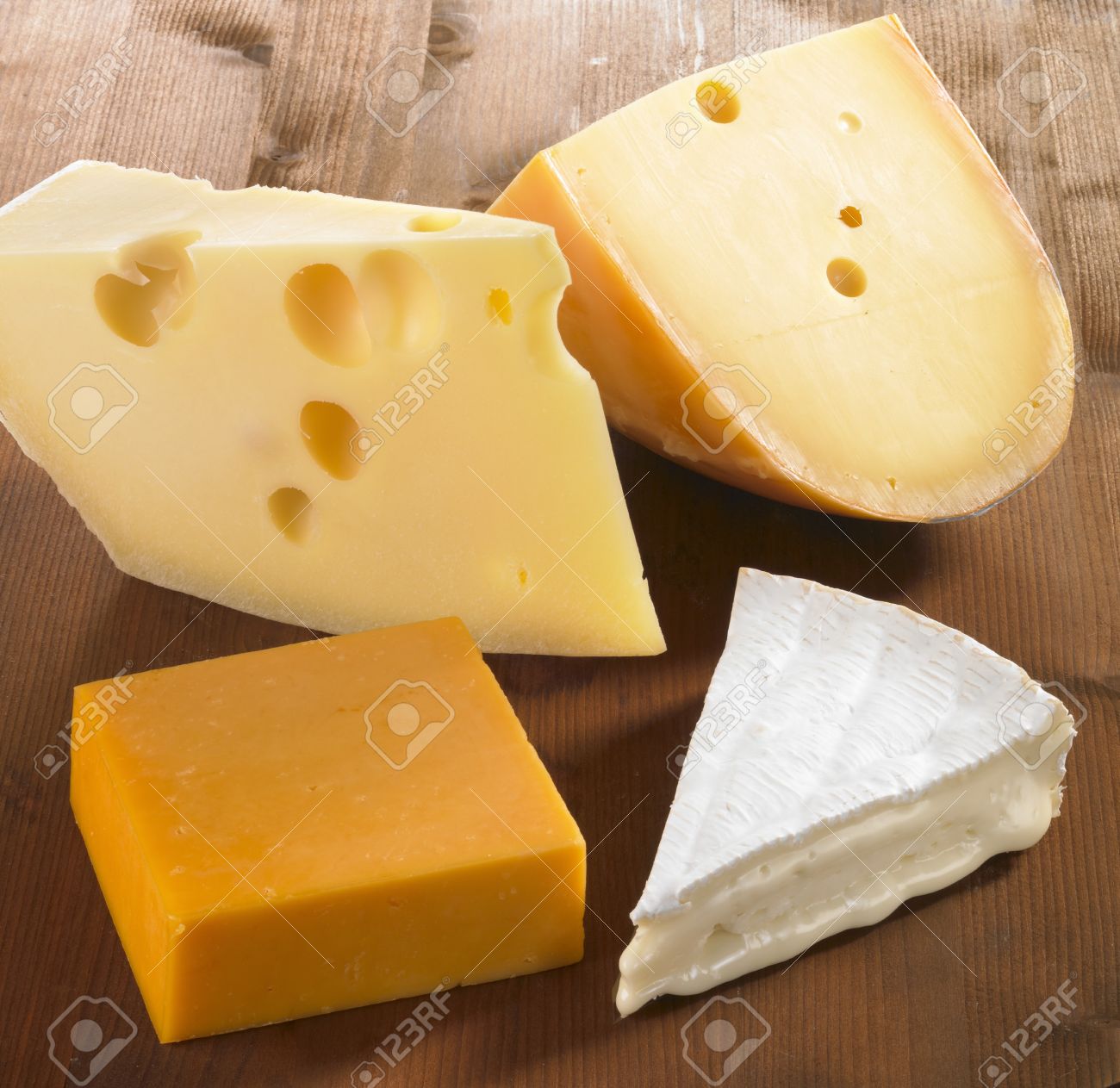 Four pieces of cheese (Emmentaler, Gouda, Cheddar and Brie)